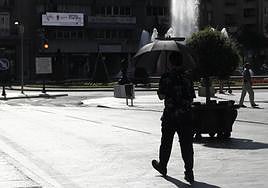 Un joven se protege del sol con un paraguas durante una ola de calor en León.