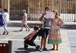 Una familia de turistas observa un mapa de León en la plaza de Regla.