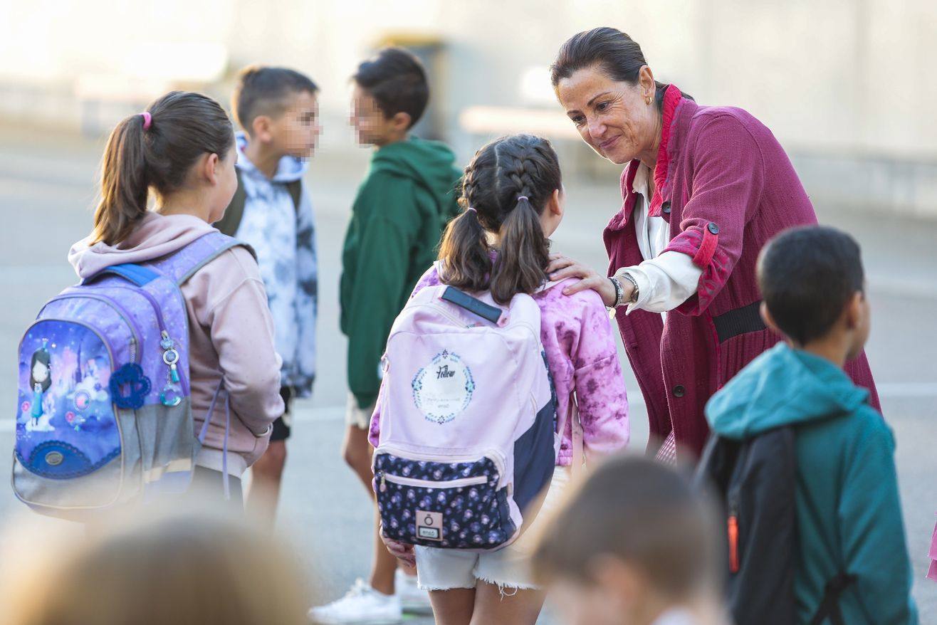 Una profesora atiende a una niña pequeña en el colegio.