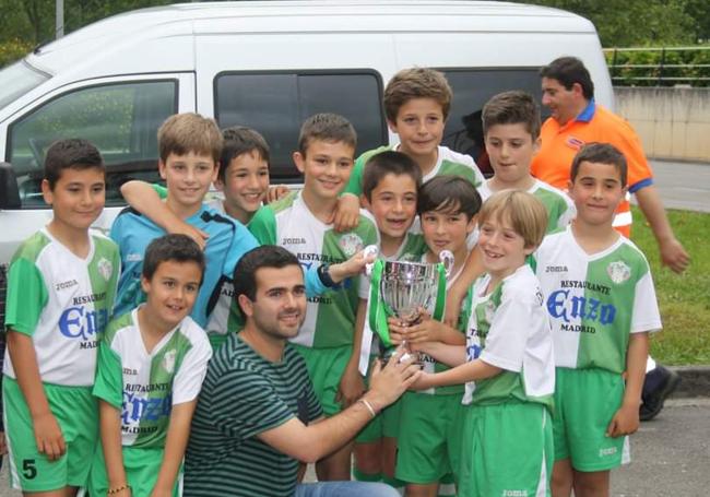 Nico Toca, el jugador más alto del equipo, en la fila posterior, posa el trofeo de campeones de liga en edad benjamín con la Peña Paco Liaño.