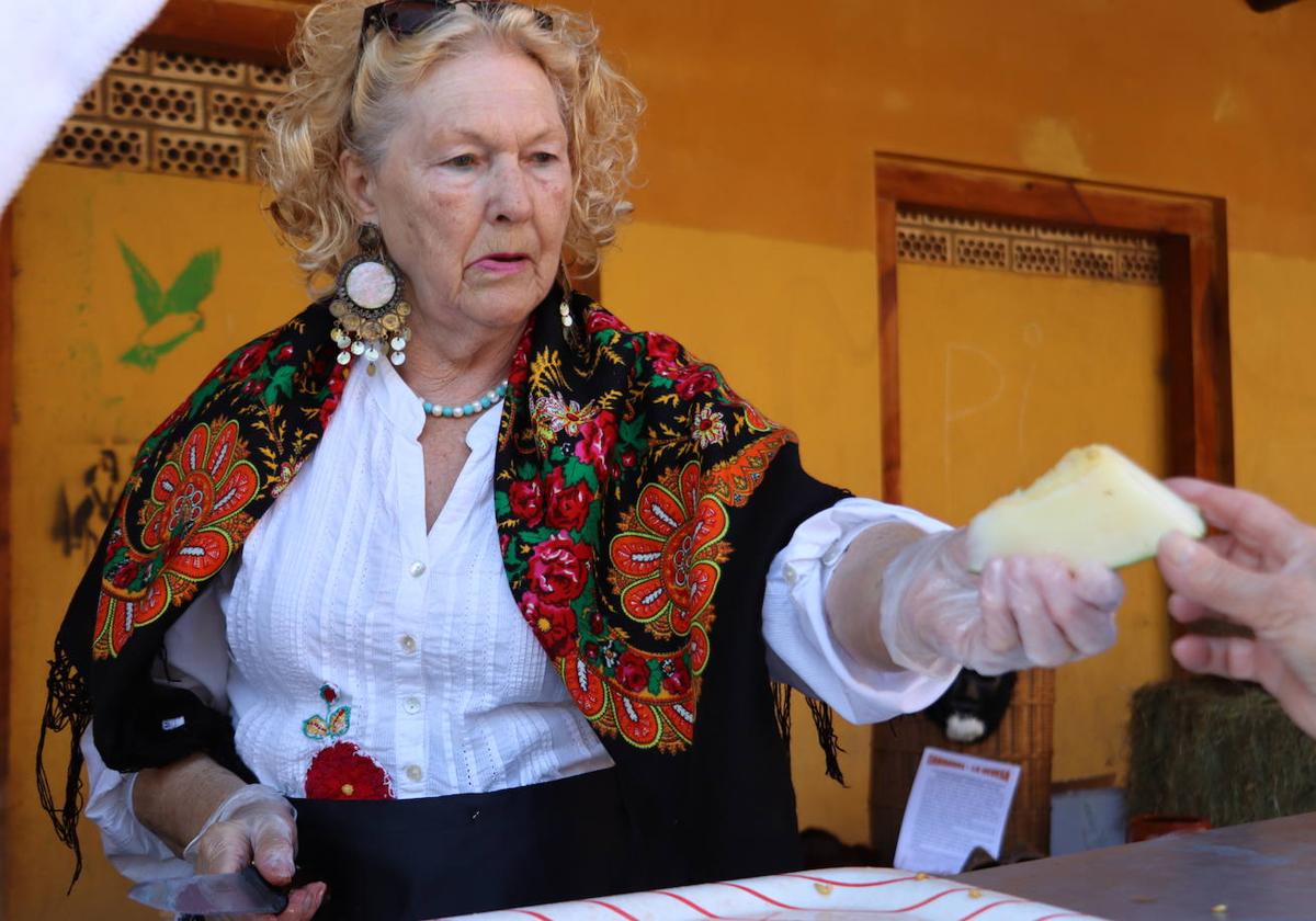 Una mujer de la asociación reparte trozos de melón en una de las actividades de la romería.