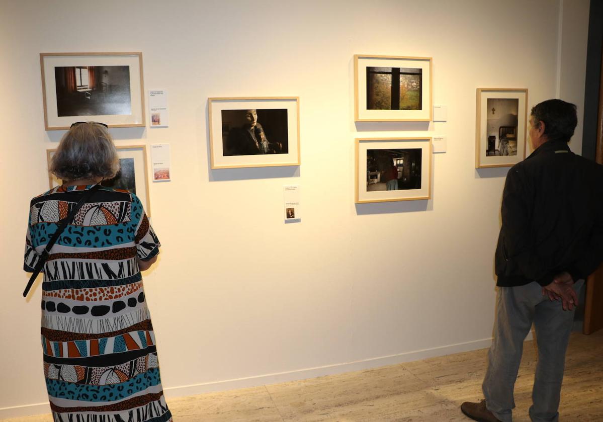 Dos personas contemplan algunas de las fotografías de la exposición.