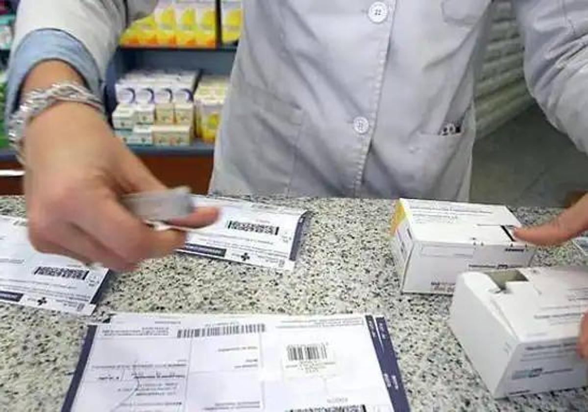 Un farmacéutico revisa las indicaciones de varias recetas.