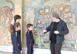 El profesor Jesús Palmero explica a alumnos del colegio Leonés la técnica del mural que Lolo dibujó en este centro.