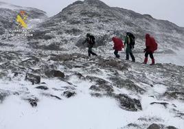 Montañeros bajando de la cima con equipos de protección