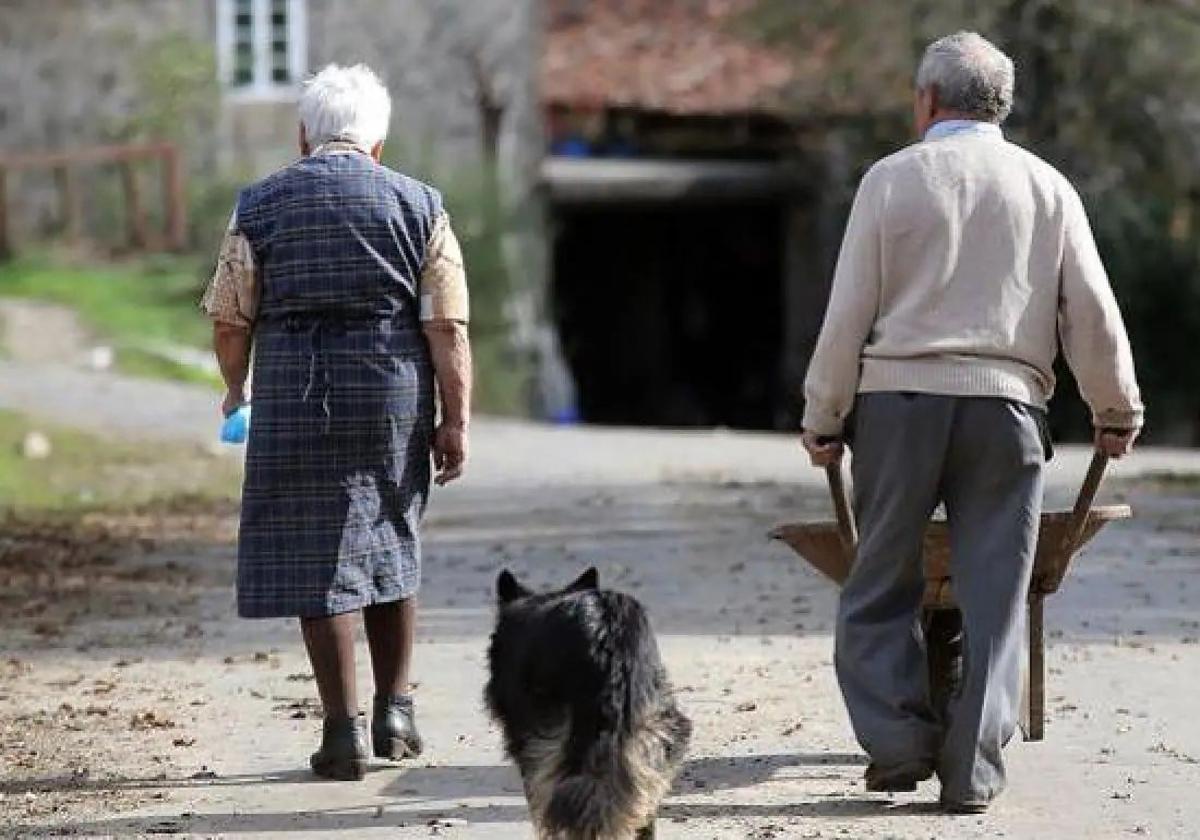 Una pareja recorre el pueblo con su mascota.