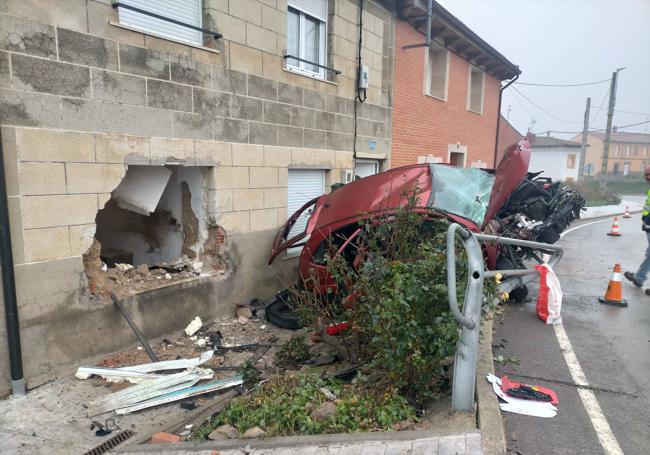 Imagen del coche y los daños en la vivienda tras el accidente.