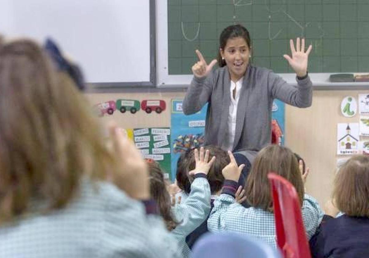 Ayudante técnico educativo dando clase en un aula infantil.