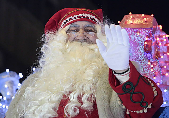 Papá Noel saluda a los niños que acudieron a verle en 2022 por las calles de León.