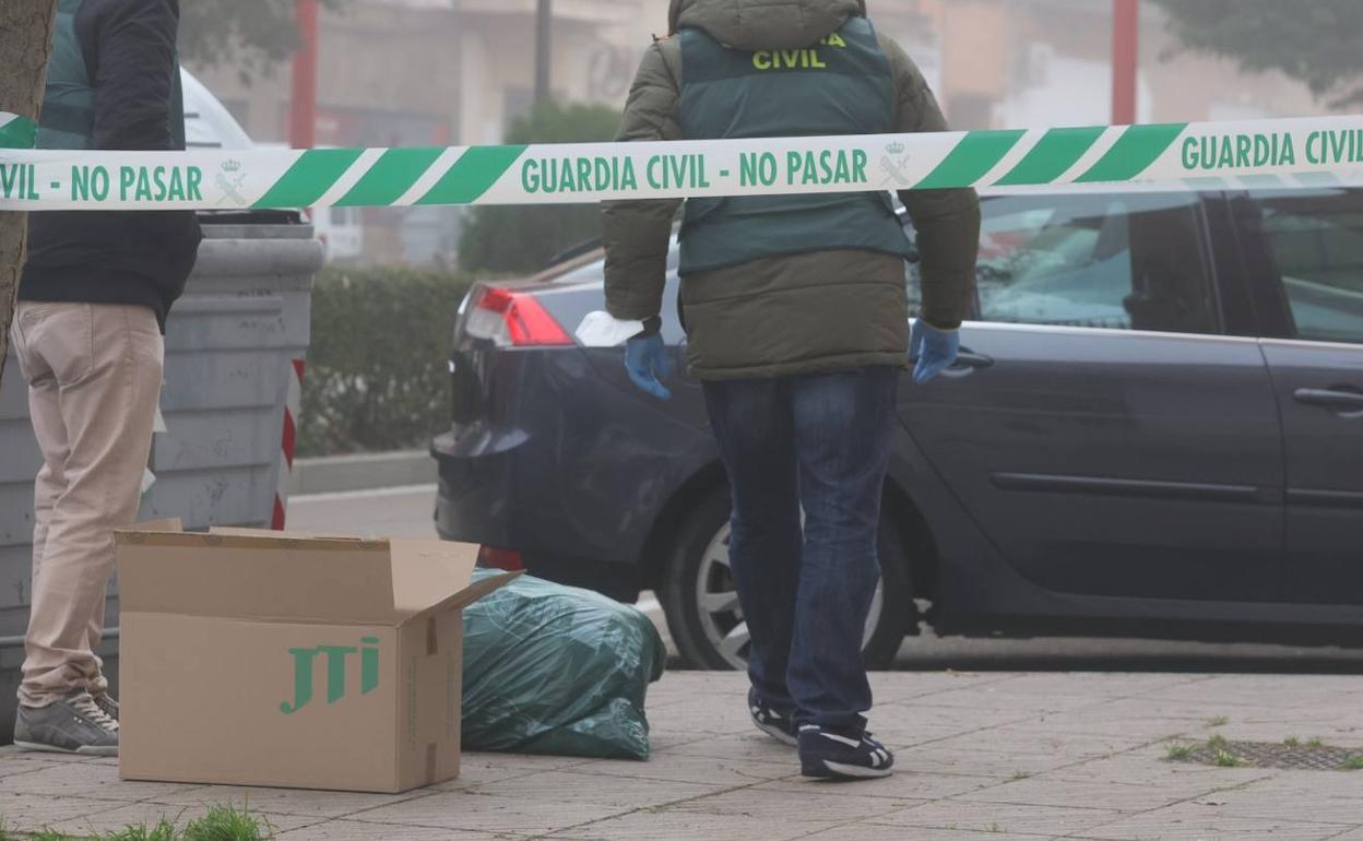 Agentes de la Guardia Civil custodian una bolsa de basura próxima al domicilio de la mujer en Santa Marta. 