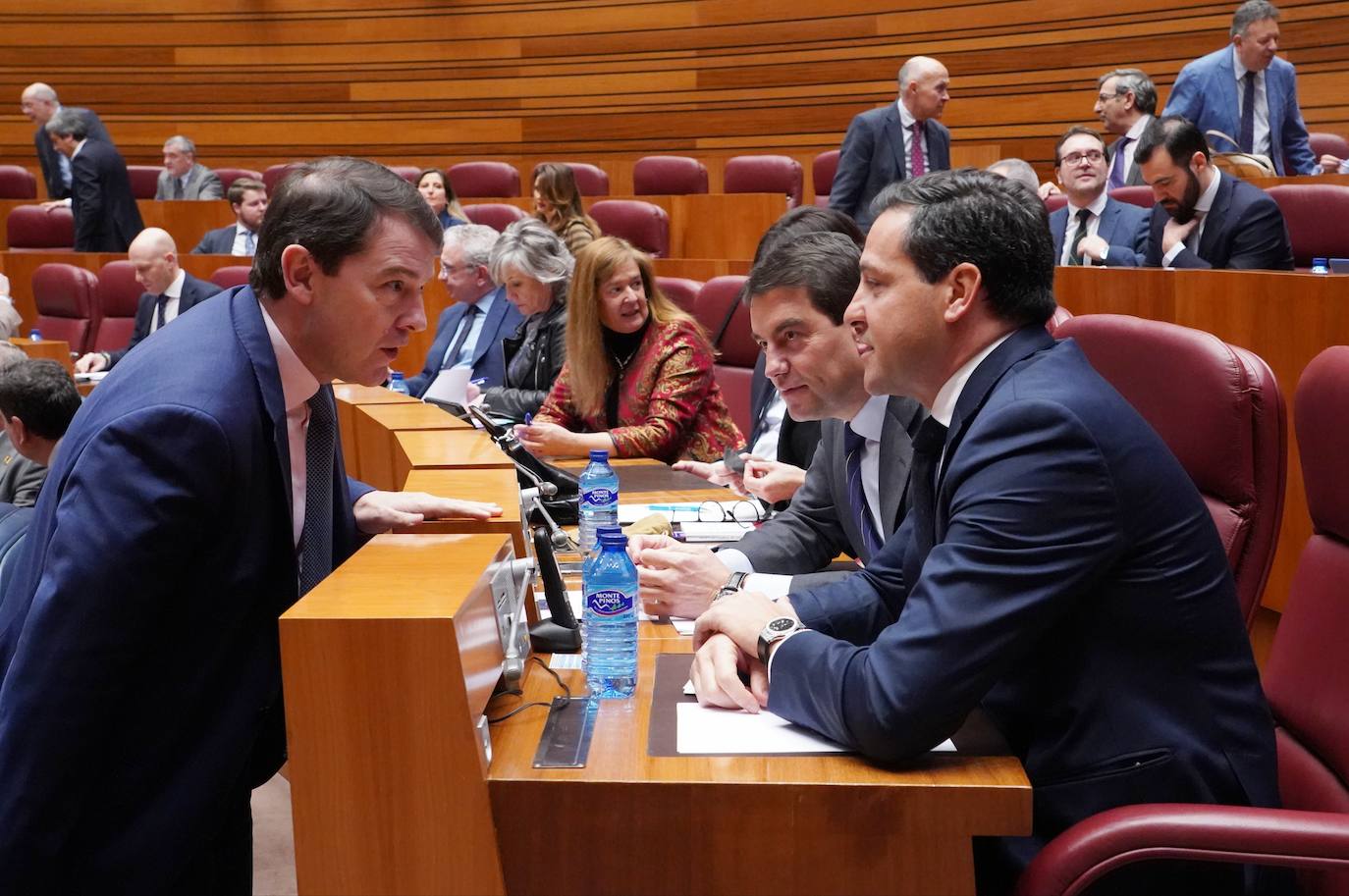 El presidente de la Junta Alfonso Fernández Mañueco conversa con los viceportavoces parlamentarios Raúl de la Hoz y Ángel Ibáñez en el Pleno extraordinario de las Cortes.