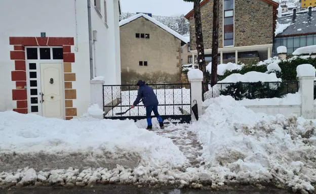 Galería. Un vecino retira nieve de la puerta de su casa en Villablino.