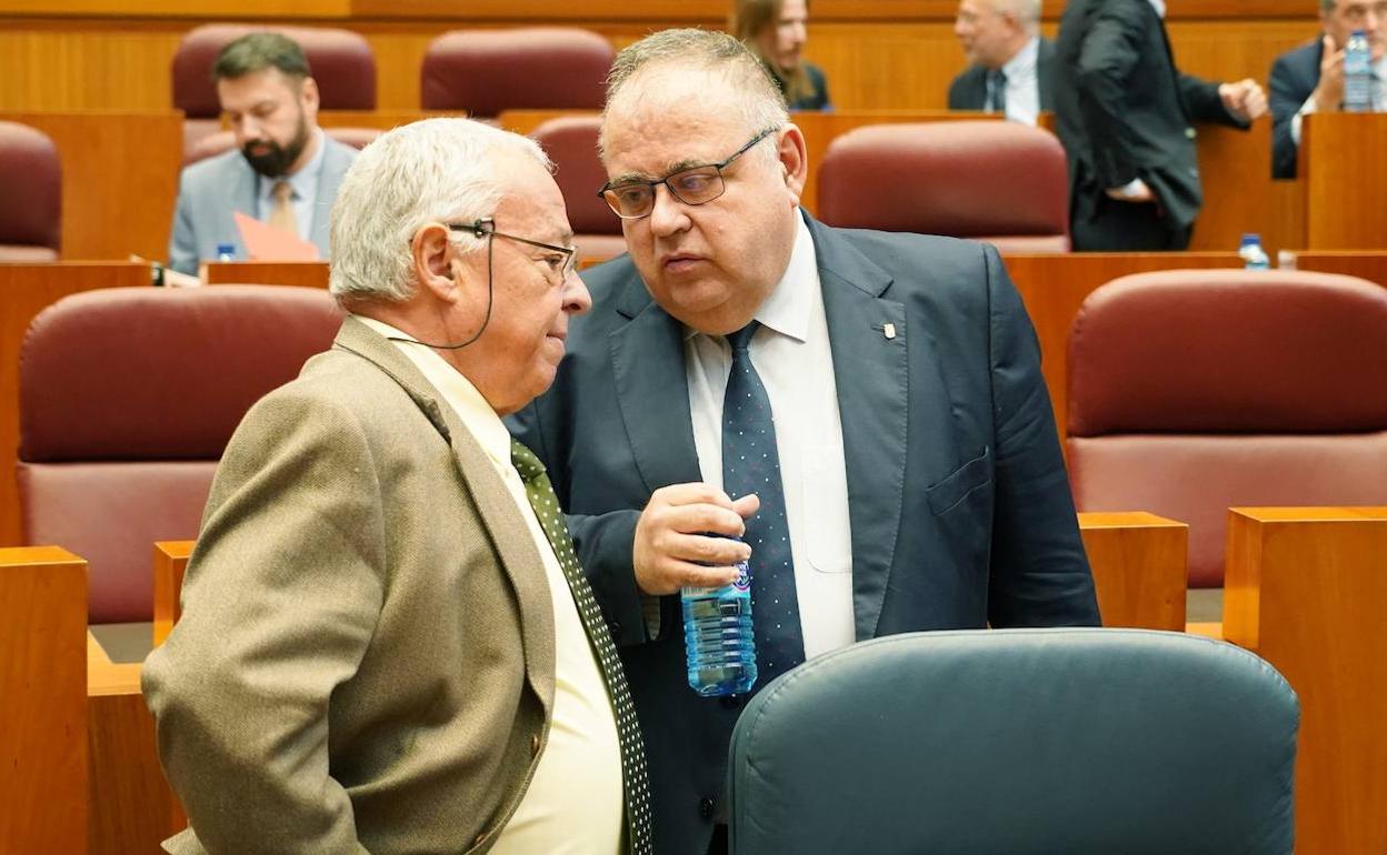 Los consejeros de Cultura, Gonzalo Santonja (I) y Sanidad, Alejandro Vázquez (D), respectivamente, conversan en el Pleno de las Cortes.