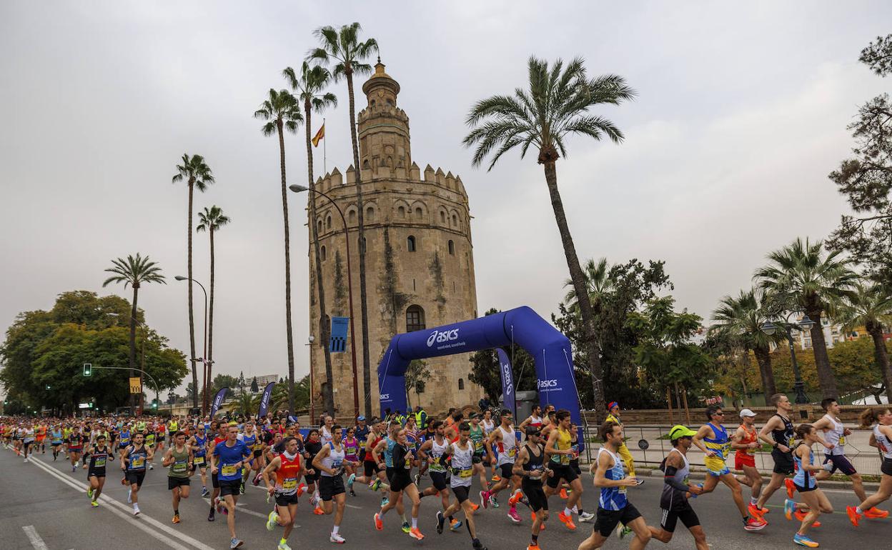 Un momento de la prueba en la que los atletas pasan por delante de la Torre del Oro. 