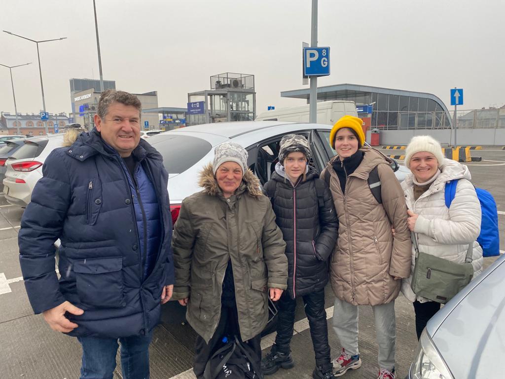 Javier Colino y David de la Riva posan junto a las familias a las que rescataron un año atrás. Ahora tienen una ONG de ayuda a Ucrania y aquellos refugiados han vuelto a Leópolis.