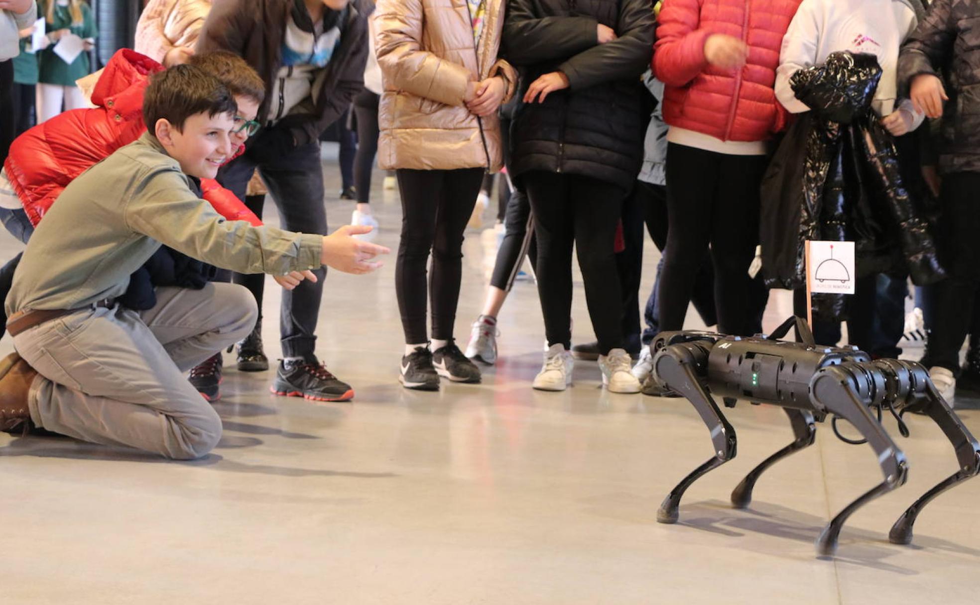 Un grupo de escolares 'juega' en la primera jornada de Expociencia con un robot en el Palacio de Exposiciones de León.