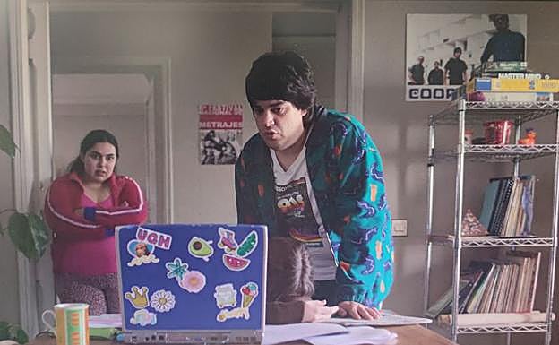 Fotograma de 'Todas las veces que nos enamoramos' con el poster de Cooper al fondo.