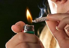 Imagen de archivo de un joven encendiendo un cigarro.