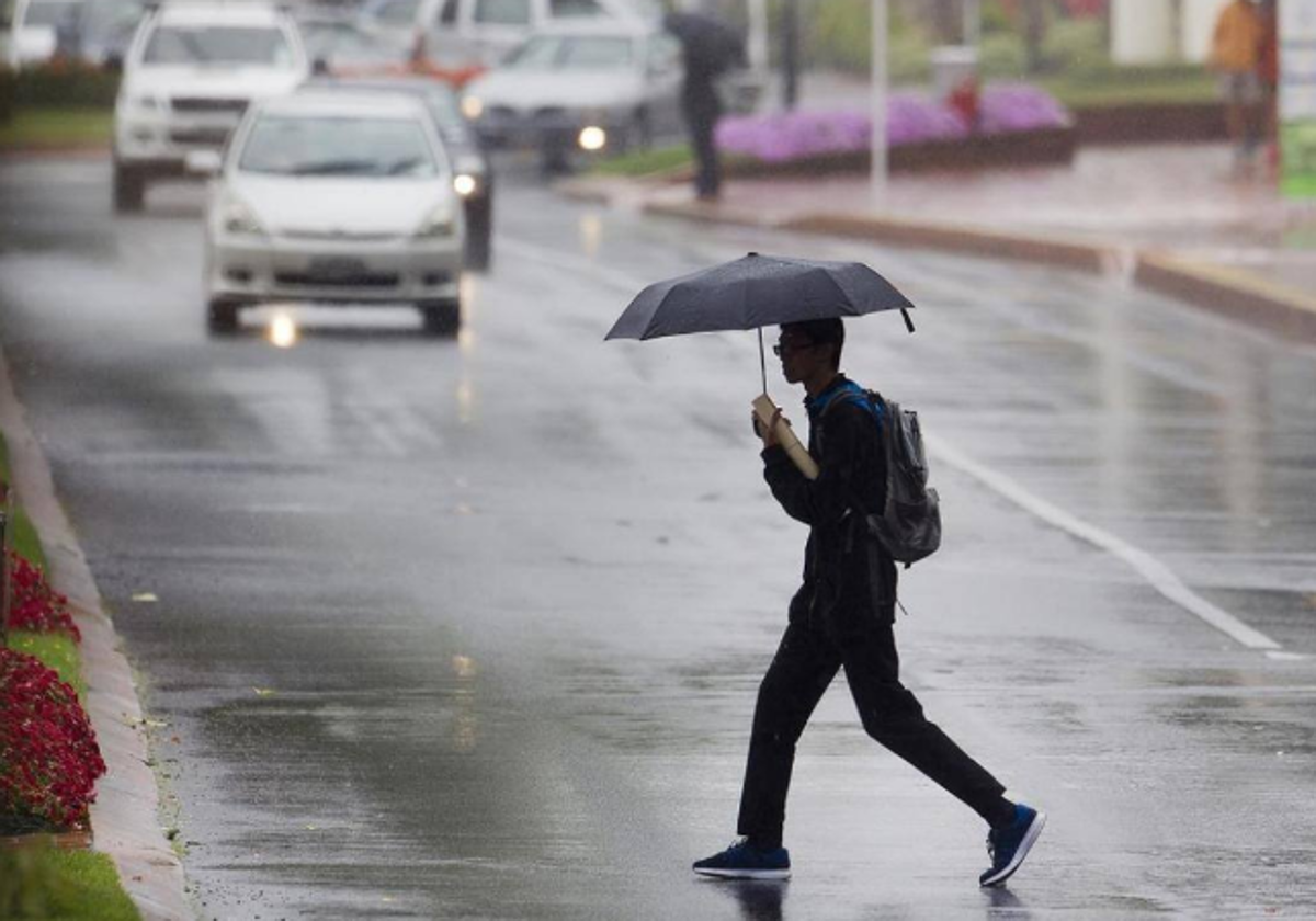 Un joven camina con su paragüas durante las lluvias en León, en imagen de archivo.