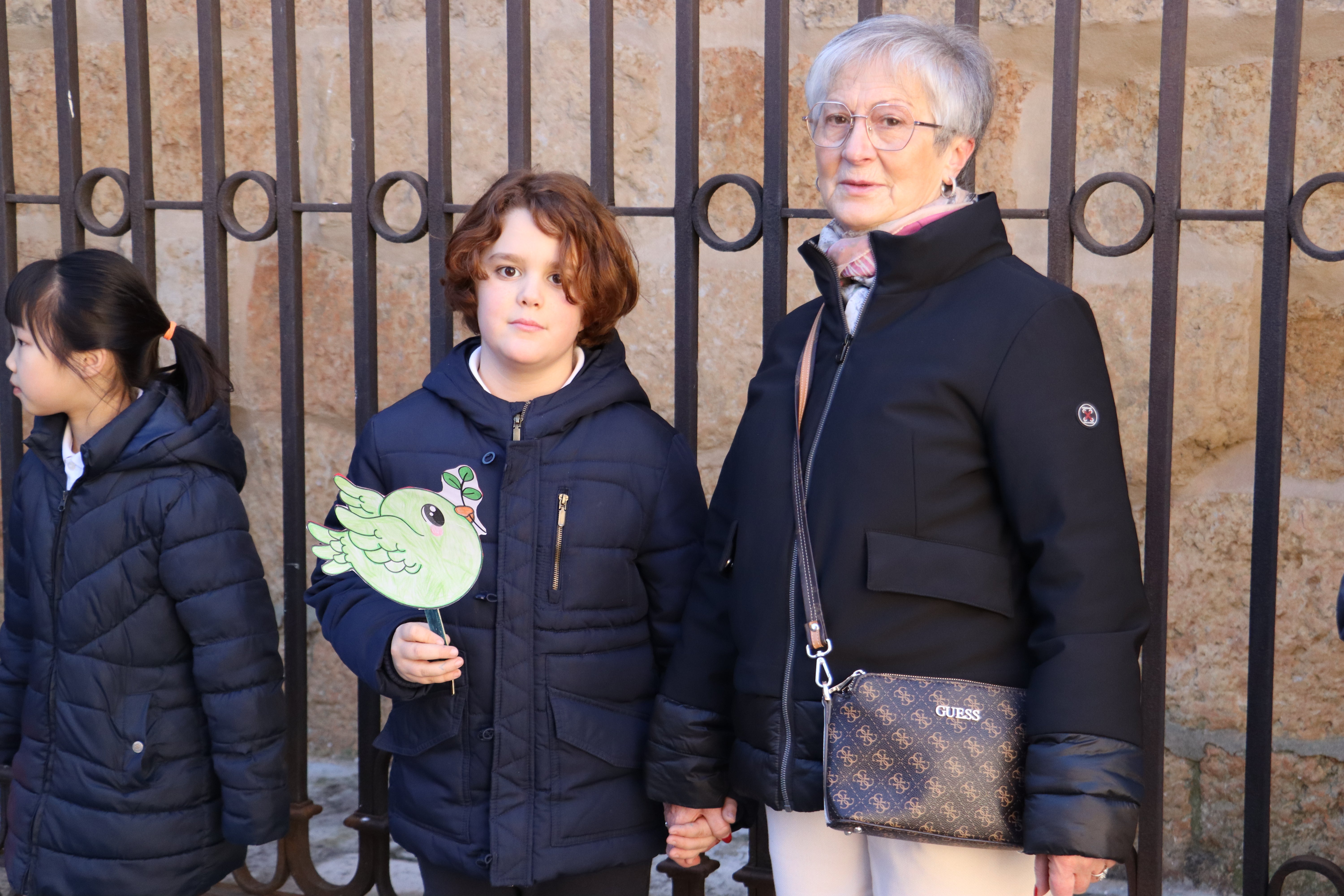 Abuela acompaña a su nieto en la actividad del centro por la paz.