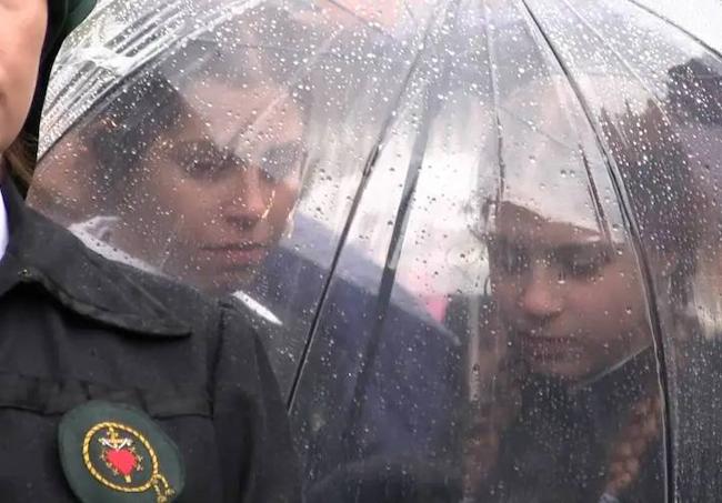 Hermanas de María del Dulce Nombre se resguardan en un paraguas tras suspenderse la procesión en 2019.