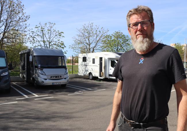 Lasse Kragh tomando el sol junto a su autocaravana Hymer en el párking de La Granja.