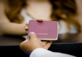 Imagen de archivo de una persona entregando su pasaporte.