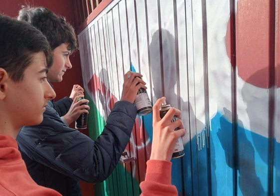 Alumnos pintando el mural.