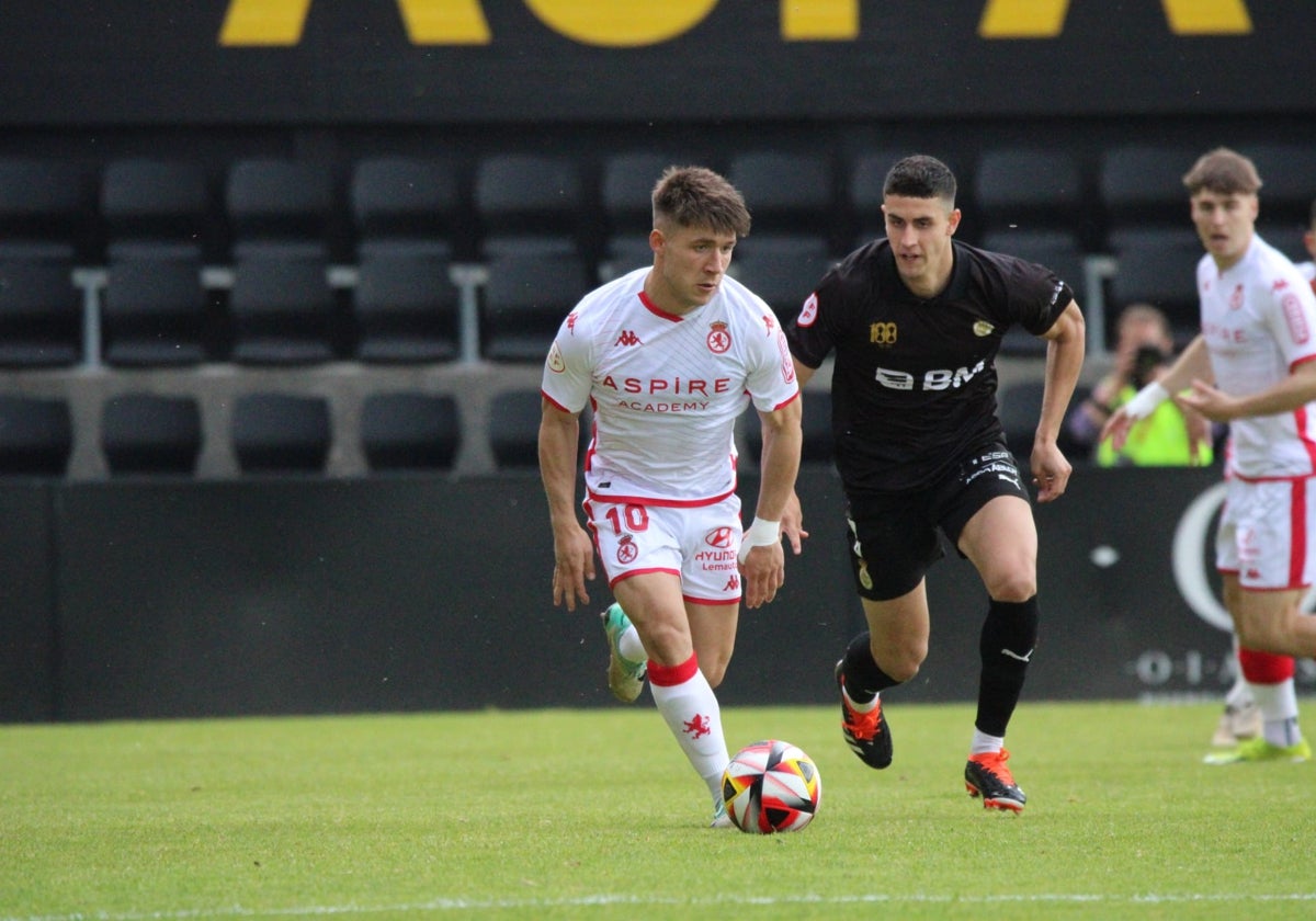 Aarón Rey conduce el balón sobre el césped del Stadium Gal