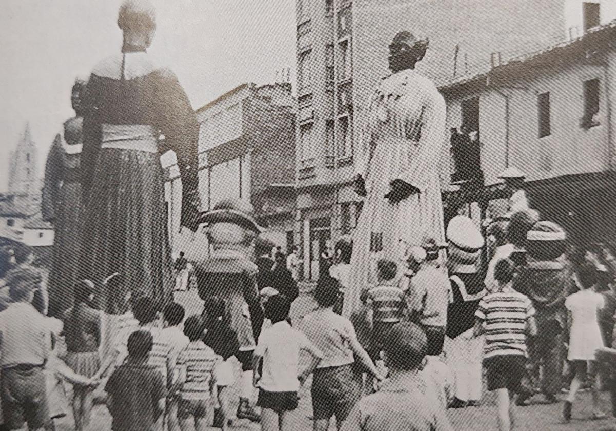 Niños acompañan a los gigantes y cabezudos durante las fiestas por el barrio de Santa Ana.