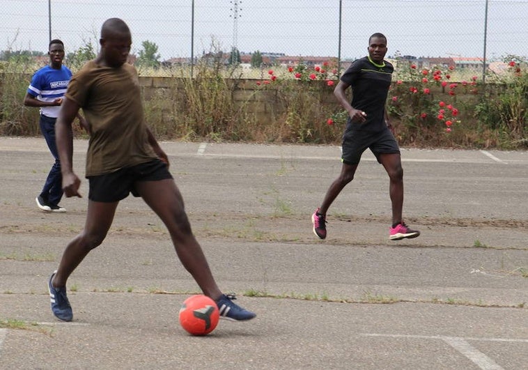 Un grupo de inmigrantes juega al balón en el chalé.