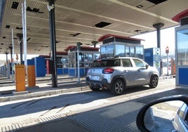 El conductor de un turismo se dispone a abonar el coste del peaje de la autopista del Huerna en las cabinas de La Magdalena.