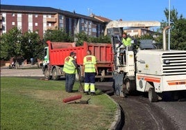 Operarios del Ayuntamiento asfaltan una carretera en León.