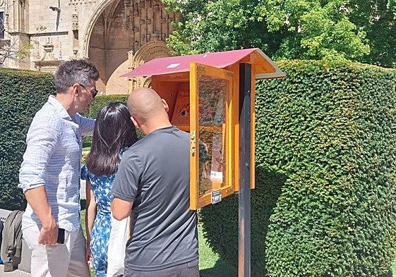 Un grupo de personas en el punto de préstamo de libros en el ágora de poesía.