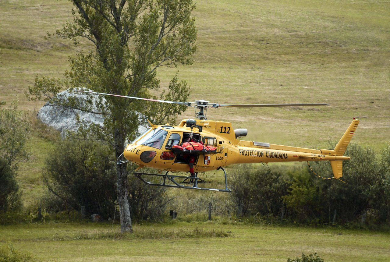 Un helicóptero del 112 de protección Ciudadana de Castilla y León en Maraña, con el cadáver de uno de los tres fallecidos al caer su helicóptero de la Guardia Civil cuando llevaban a cabo un rescate.