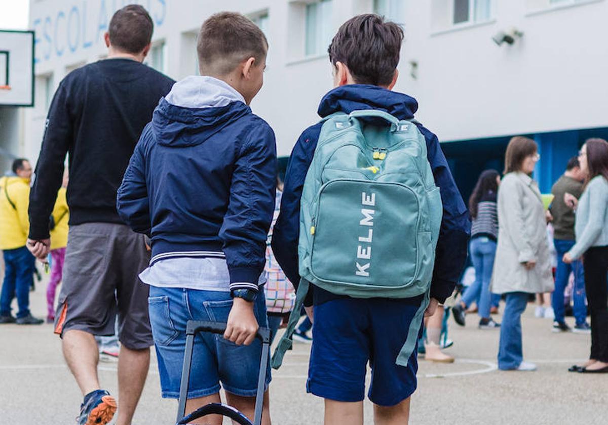 Dos alumnos, a la entrada de un centro escolar.