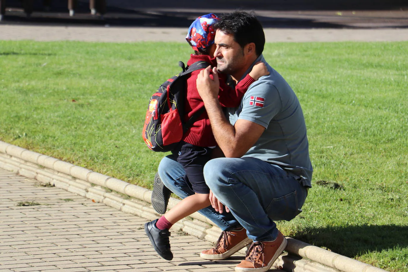 Un niño se despide de su padre antes de entrar a clase.