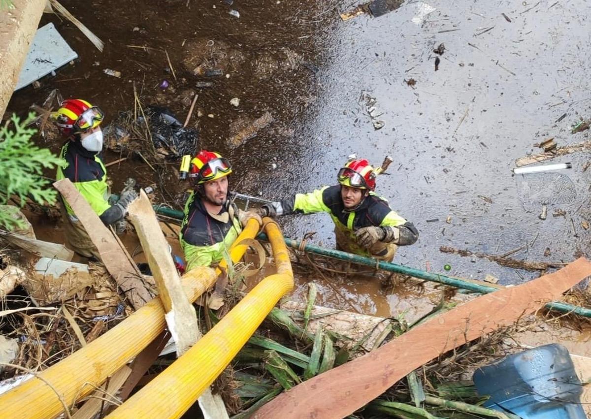 Imagen secundaria 1 - Bomberos de León trabajan en garajes de Valencia anegados tras la DANA