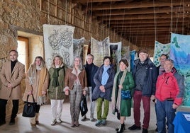 Algunos de los artistas junto a las obras en el claustro del monasterio.