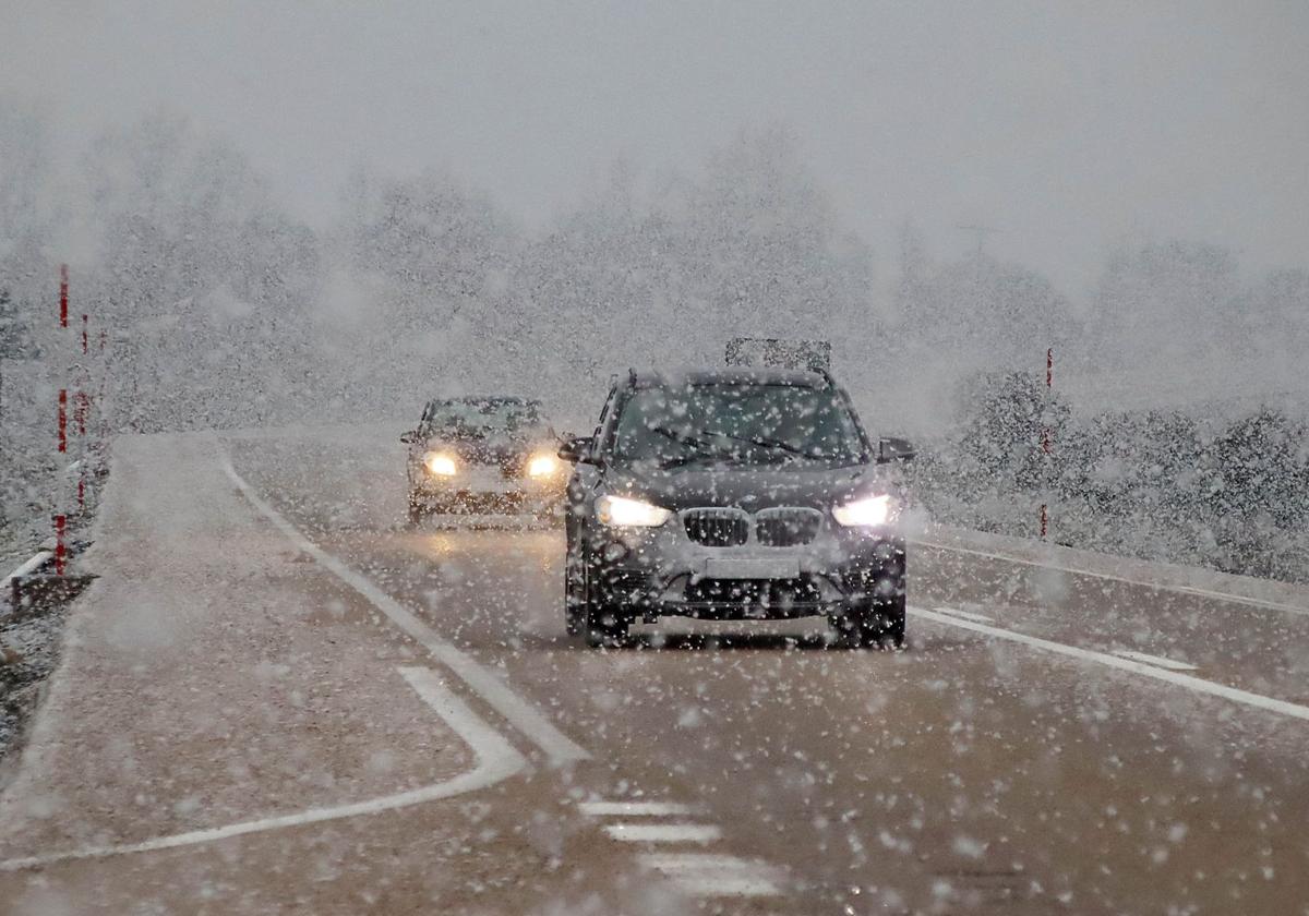 Vehículos circulando bajo una nevada en León.