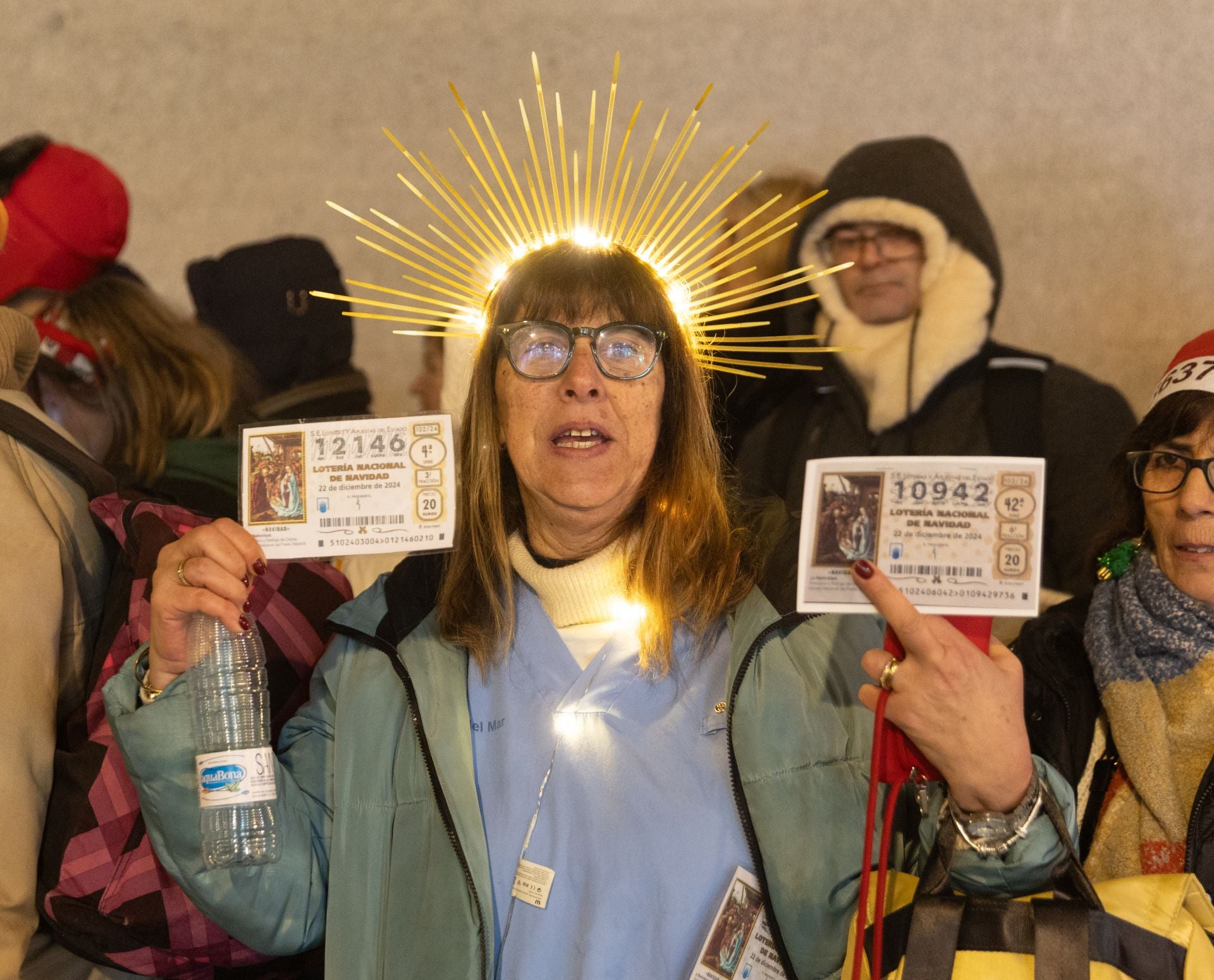 Una mujer con sus décimos hace cola antes de entrar a la celebración del Sorteo Extraordinario de la Lotería de Navidad 2024.