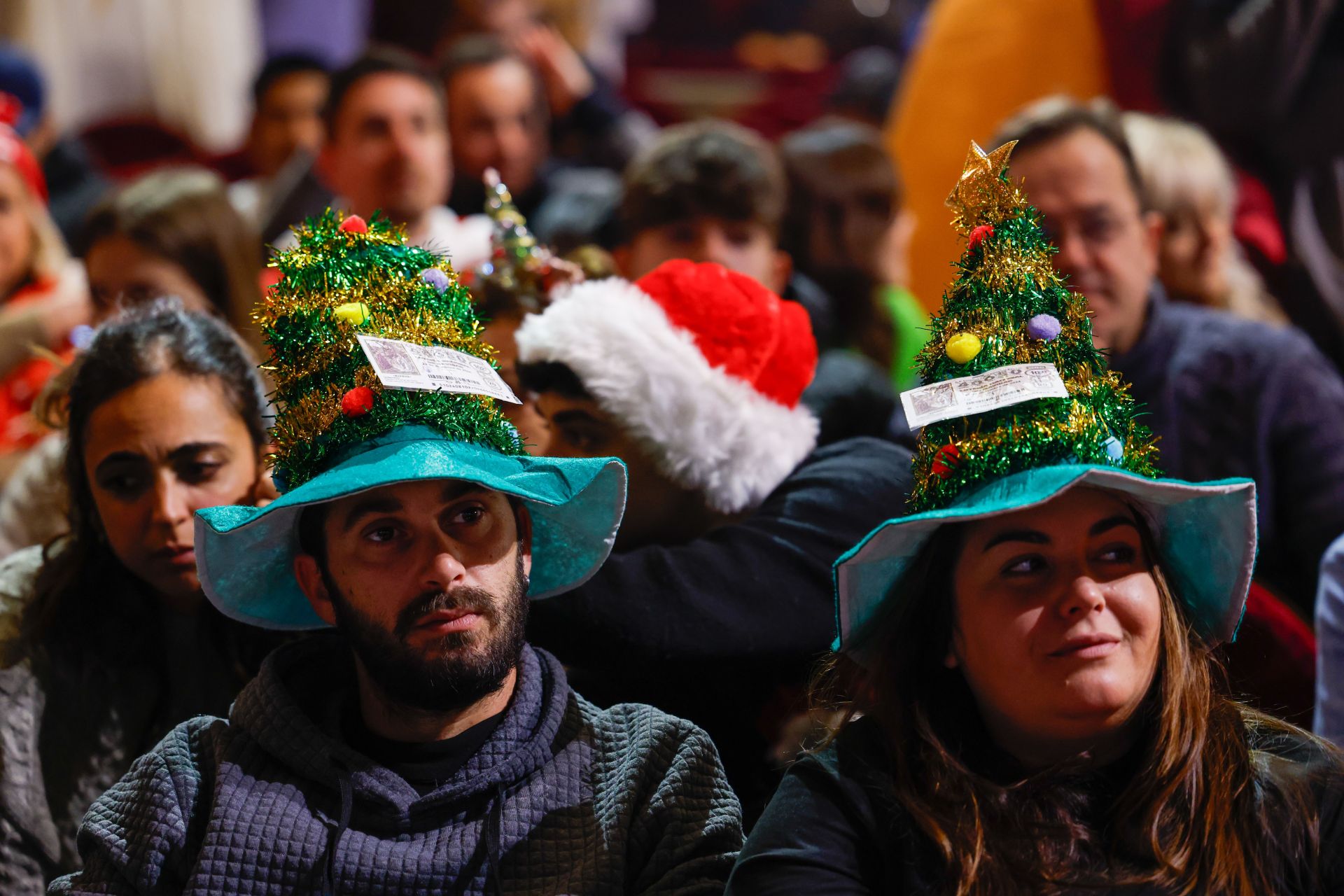 Varias personas asisten al sorteo de la Lotería de Navidad que se celebra este domingo en el Teatro Real, en Madrid