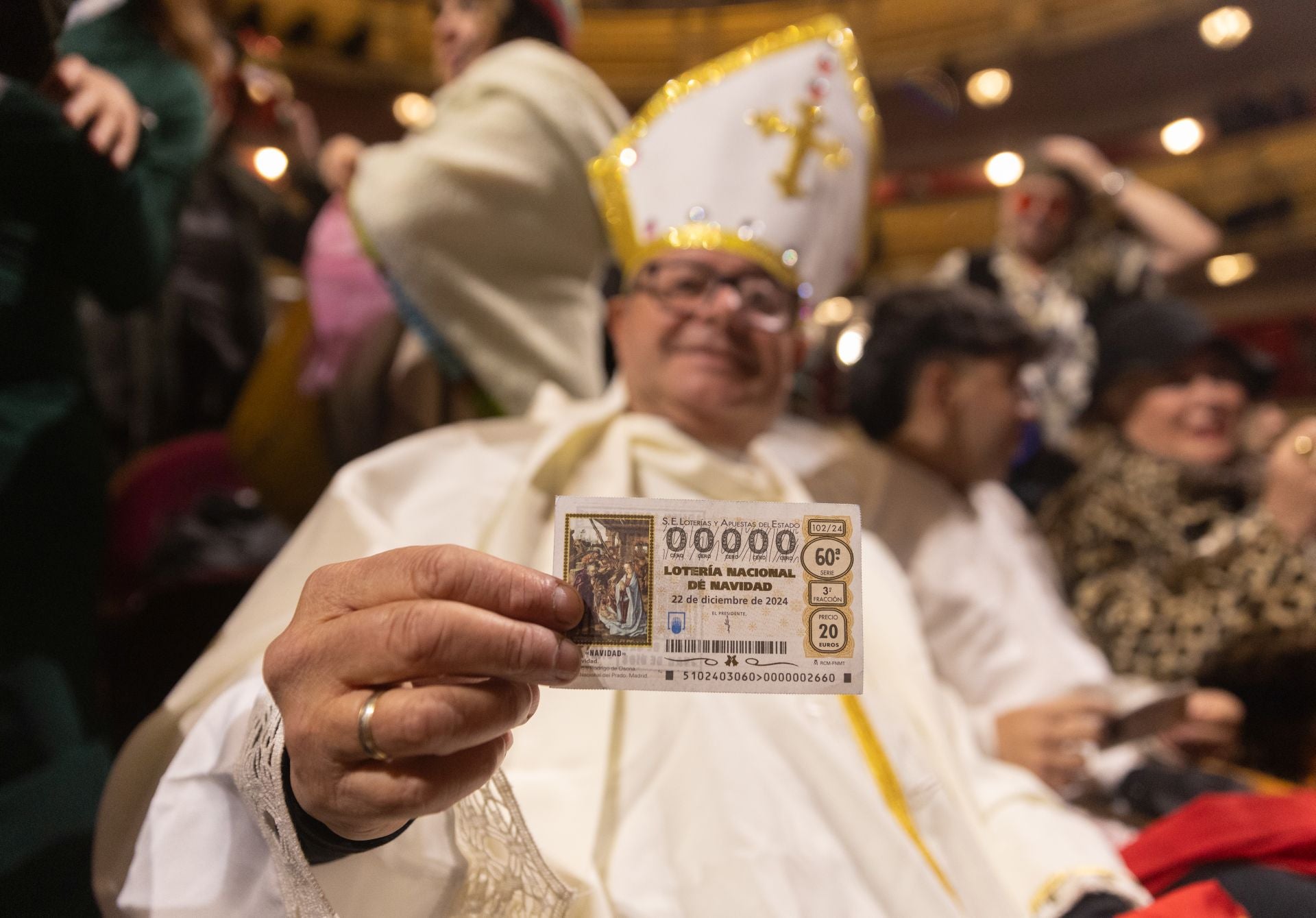 Un hombre disfrazado de papa con su décimo antes de comenzar la celebración del Sorteo Extraordinario de la Lotería de Navidad 2024.