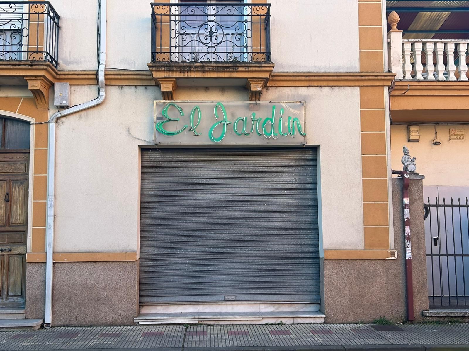 Entrada con la persiana bajada del pub El Jardín.