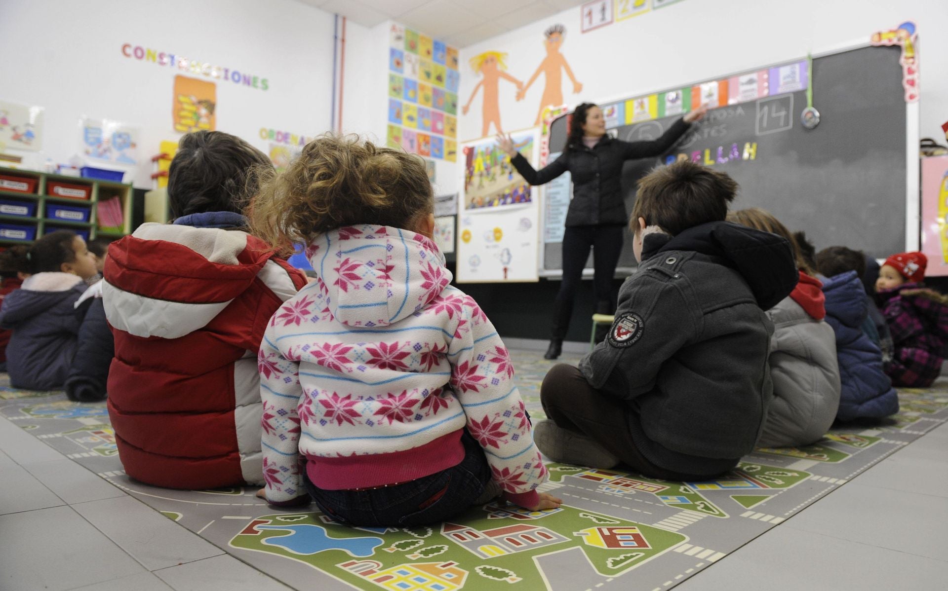 Unos niños y su profesore reciben clase con abrigo en una imagen de archivo