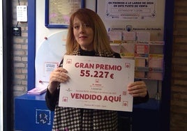 La gerente de la administración de lotería posa con el cartel del premio dado.