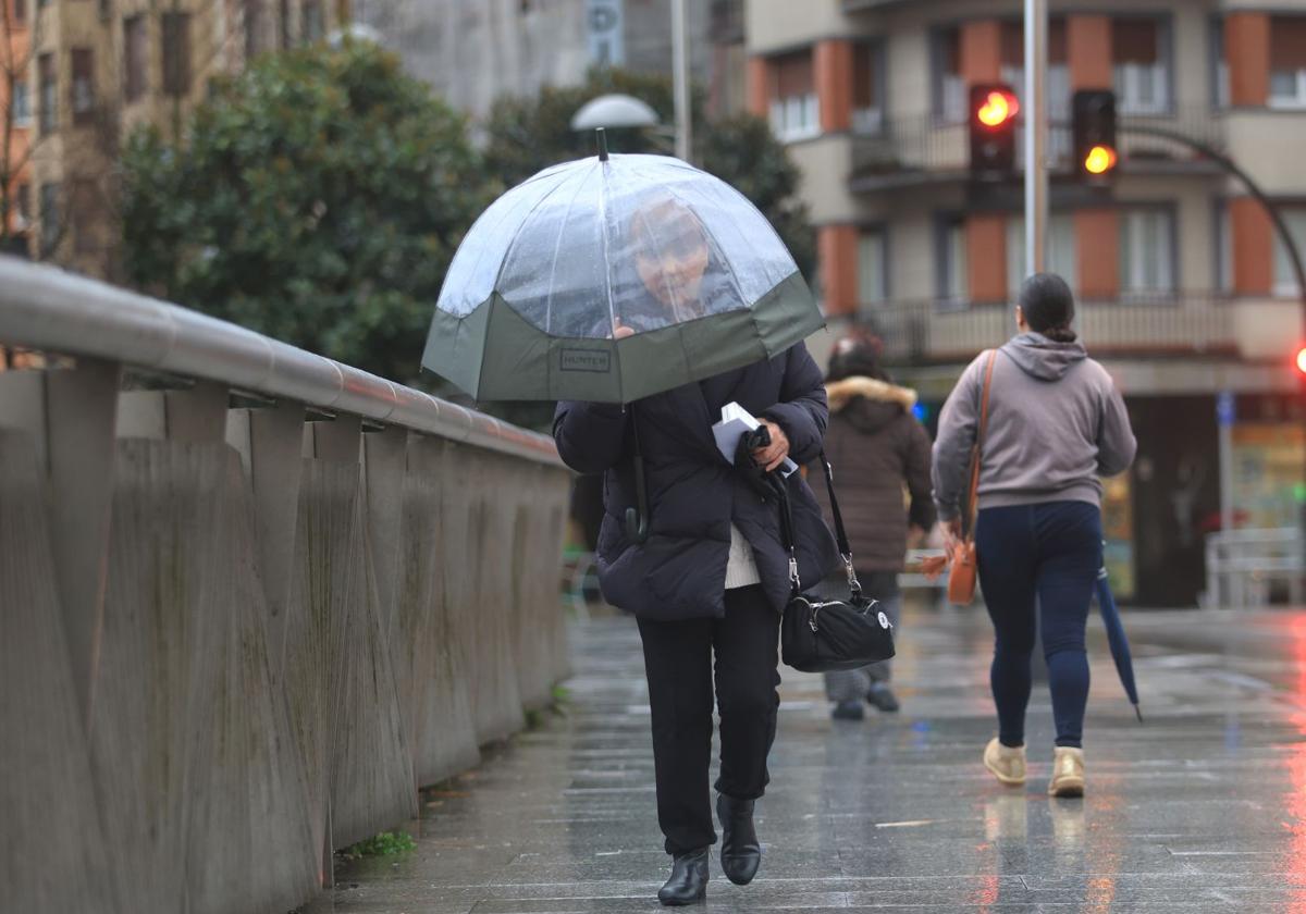 Una mujer camina bajo la lluvia con el paraguas abierto en una imagen de archivo.