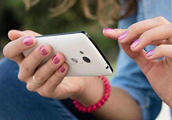 Imagen de archivo de una usuaria con su teléfono móvil.