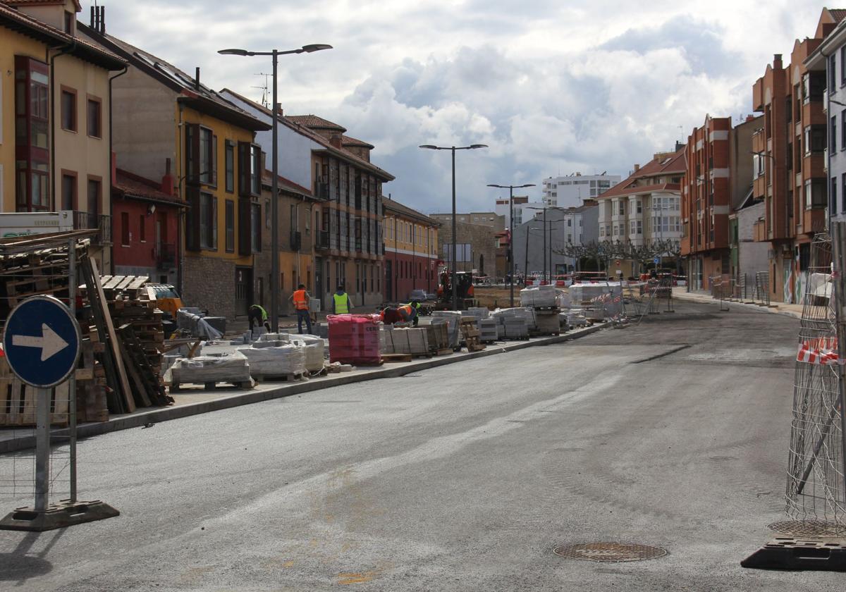 Parte de la calzada asfaltada y operarios trabajando en el adoquinado del tramo de Ronda Interior de León que une la plaza del Espolón con la calle Palomera.