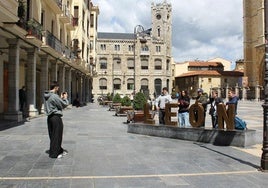 Un grupo de turistas disfrutan del tiempo soleado en la plaza de Regla de León.